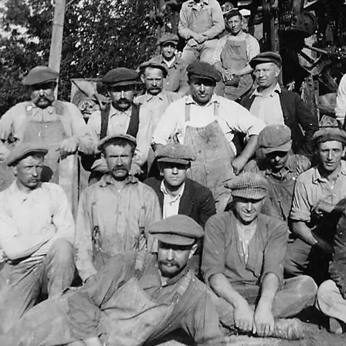 A black and white photo of a group of workers posing for the camera