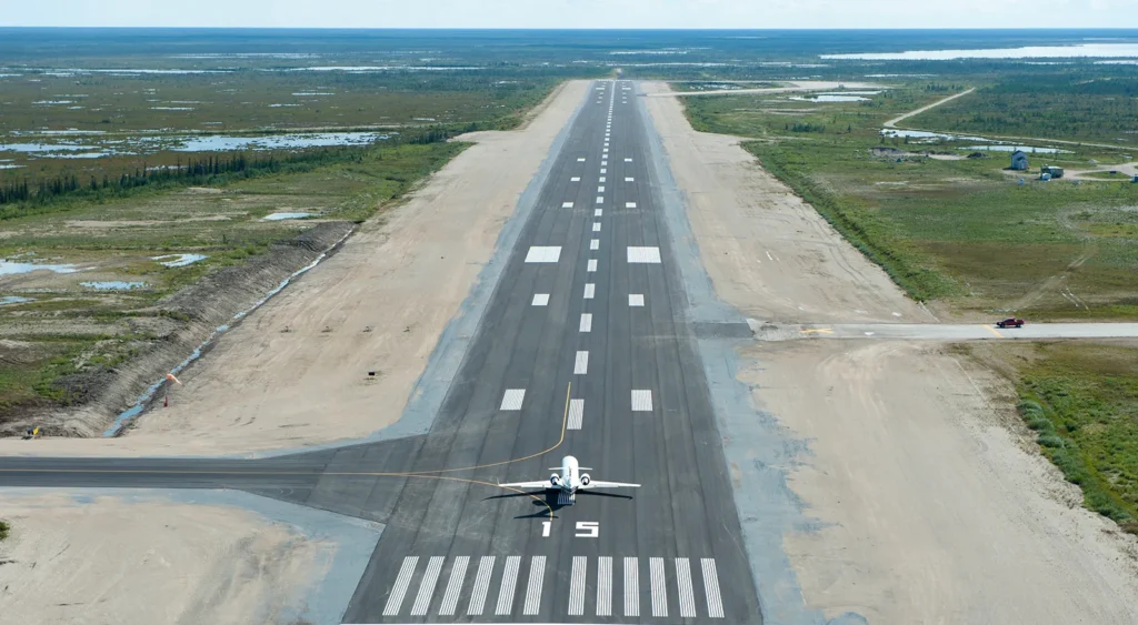 A long airport runway with an airplane readying for take-off